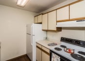 Thumbnail 8 of 19 - Grand Forks, ND Bristol Park Apartments. a kitchen with white cabinets and a white stove top oven
