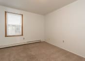 Thumbnail 14 of 19 - Grand Forks, ND Bristol Park Apartments. a bedroom with white walls and carpet