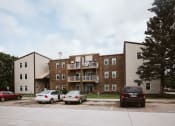 Thumbnail 16 of 19 - Grand Forks, ND Bristol Park Apartments.  A brick apartment building with cars parked in front of it