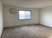 Thumbnail 8 of 13 - an empty living room with a window and carpet. Fargo, ND Brookfield Apartments
