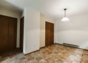 Thumbnail 7 of 11 - Grand Forks, ND Carling Manor Apartments. a dining room with white walls and a brown tile floor
