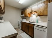 Thumbnail 6 of 11 - Grand Forks, ND Carling Manor Apartments.  a kitchen with white appliances and wooden cabinets