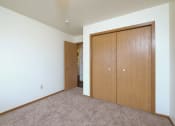 Thumbnail 32 of 41 - a bedroom with a closet and a door to a hallway. Fargo, ND Carlton Place Apartments