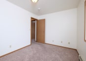 Thumbnail 28 of 41 - a bedroom with carpet and a door to a closet. Fargo, ND Carlton Place Apartments