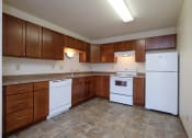 Thumbnail 26 of 41 - an empty kitchen with white appliances and wooden cabinets