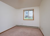 Thumbnail 22 of 41 - a bedroom with white walls and a window. Fargo, ND Carlton Place Apartments