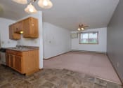Thumbnail 20 of 41 - an empty living room with a kitchen and a ceiling fan. Fargo, ND Carlton Place Apartments