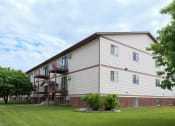 Thumbnail 40 of 41 - the exterior of a building with a green lawn and trees. Fargo, ND Carlton Place Apartments