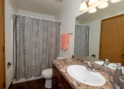 Thumbnail 11 of 13 - a bathroom with a sink and a shower and a toilet. Fargo, ND Cedars 2 Apartments