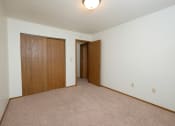 Thumbnail 8 of 13 - a bedroom with a carpeted floor and a door to a closet. Fargo, ND Cedars 2 Apartments