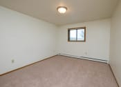 Thumbnail 7 of 13 - a bedroom with white walls and a window. Fargo, ND Cedars 2 Apartments
