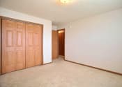 Thumbnail 16 of 20 - An empty room with wooden doors and a white wall