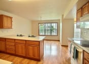 Thumbnail 15 of 20 - An empty kitchen with wooden cabinets and a white counter top
