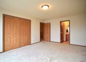 Thumbnail 17 of 20 - A bedroom with two closets and a door to a hallway