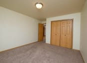Thumbnail 9 of 20 - A living room with a closet and a door to a hallway