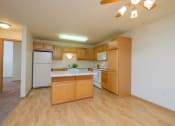 Thumbnail 7 of 20 - An empty kitchen with wooden cabinets and a white refrigerator