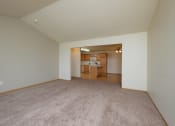 Thumbnail 5 of 20 - A spacious living room with carpet and a kitchen