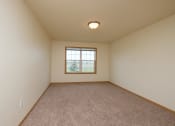 Thumbnail 8 of 20 - A bedroom with carpeted floors and a window.