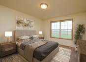 Thumbnail 4 of 20 - A bedroom with a large bed and a window. West Fargo, ND Charleswood Townhomes.