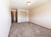 Thumbnail 10 of 19 - Grand Forks, ND Cherry Creek Apartments. A bedroom in unit 223 that has a window, white walls, a closet, and carpeted floors