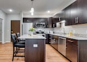 Thumbnail 62 of 83 - a kitchen with a island and a table with chairs. Circle Pines, MN Lexington Lofts