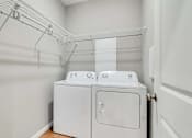 Thumbnail 59 of 83 - a washer and dryer in a laundry room with a rack on the wall Lexington Lofts
