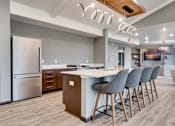 Thumbnail 78 of 83 - a kitchen with a island and chairs in front of a refrigerator. Circle Pines, MN Lexington Lofts
