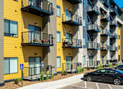 Thumbnail 83 of 83 - an apartment with balconies and cars parked in front of them. Circle Pines, MN Lexington Lofts