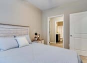 Thumbnail 47 of 83 - a bedroom with a bed and a door to a bathroom. Circle Pines, MN Lexington Lofts