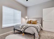 Thumbnail 37 of 83 - a bedroom with a bed next to a window. Circle Pines, MN Lexington Lofts
