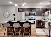 Thumbnail 35 of 83 - a kitchen with stainless steel appliances and wooden cabinets. Circle Pines, MN Lexington Lofts