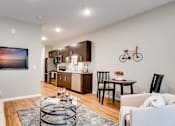 Thumbnail 27 of 83 - a living room and kitchen with a couch and a table. Circle Pines, MN Lexington Lofts