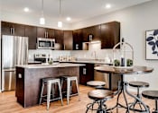 Thumbnail 4 of 83 - a kitchen with a counter and a bar with stools. Circle Pines, MN Lexington Lofts