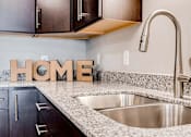 Thumbnail 3 of 83 - a kitchen with a sink and home letters on the counter. Circle Pines, MN Lexington Lofts