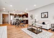 Thumbnail 1 of 83 - a living room with a couch and a table in front of a kitchen. Circle Pines, MN Lexington Lofts