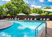 Thumbnail 81 of 83 - a swimming pool with chairs and umbrellas. Circle Pines, MN Lexington Lofts