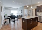 Thumbnail 16 of 83 - an open kitchen and dining room with a table and chairs. Circle Pines, MN Lexington Lofts