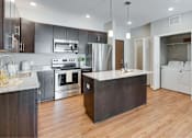 Thumbnail 17 of 83 - an open kitchen with a large island in the middle. Circle Pines, MN Lexington Lofts
