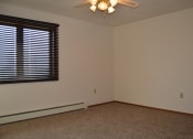 Thumbnail 6 of 6 - An empty living room with a ceiling fan and a window