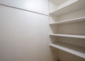 Thumbnail 23 of 25 - an empty closet in a room with white walls and shelves. Fargo, ND Betty Ann Apartments