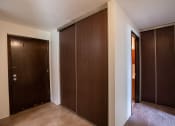 Thumbnail 11 of 14 - a closet with two doors and a door to a bathroom. Coon Rapids, MN Robinwood Apartments