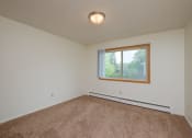 Thumbnail 25 of 42 - an empty living room with carpet and a window. Fargo, ND Country Club Apartments.