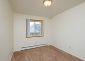 Thumbnail 22 of 42 - an empty living room with carpet and a window. Fargo, ND Country Club Apartments.