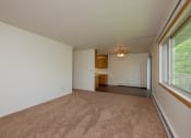 Thumbnail 20 of 42 - an empty living room with a large window and carpet. Fargo, ND Country Club Apartments.