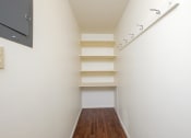 Thumbnail 28 of 42 - a corridor with white walls and shelves and a wood floor. Fargo, ND Country Club Apartments.