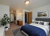 Thumbnail 7 of 23 - a bedroom with a large bed and a potted plant. Fargo, ND Countryside Apartments