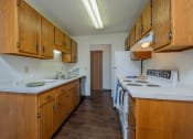 Thumbnail 8 of 23 - a kitchen with white appliances and wooden cabinets and a white stove. Fargo, ND Countryside Apartments