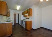 Thumbnail 9 of 23 - an empty kitchen with wooden cabinets and a stove and a refrigerator. Fargo, ND Countryside Apartments