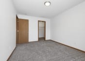 Thumbnail 10 of 14 - St. Louis Park, MN Courtyard Apartments. A  bedroom with a carpeted floor and a door to a closet