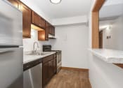 Thumbnail 13 of 14 - St. Louis Park, MN Courtyard Apartments. a kitchen with wood flooring and white walls